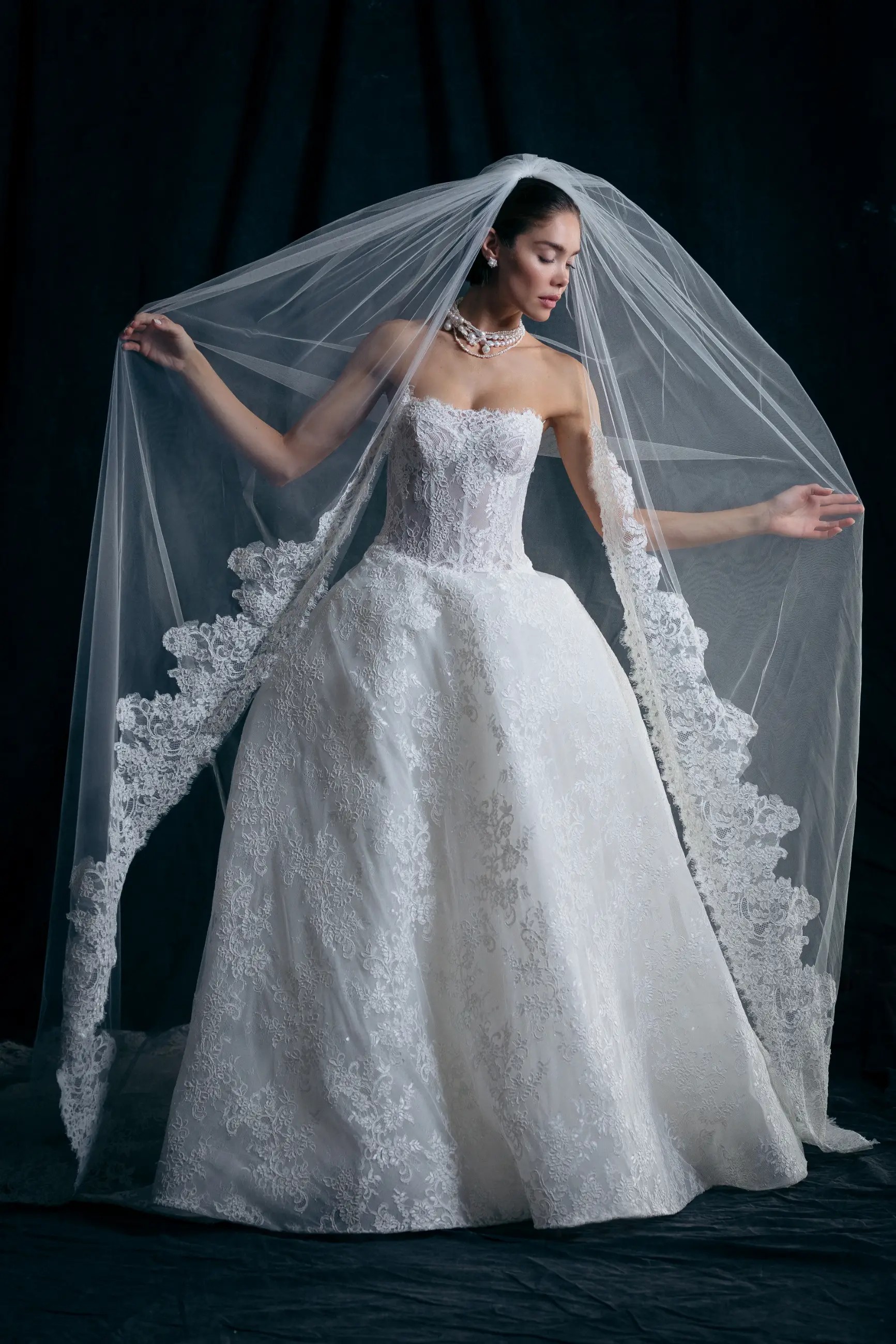Model is wearing a lace ball gown wedding dress with a sweetheart neckline with french alencon lace by mark ingram