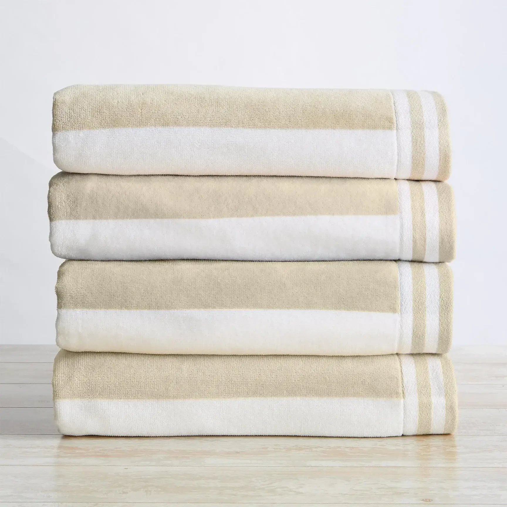 Image shows a stack of striped plush beach towels neatly folded.