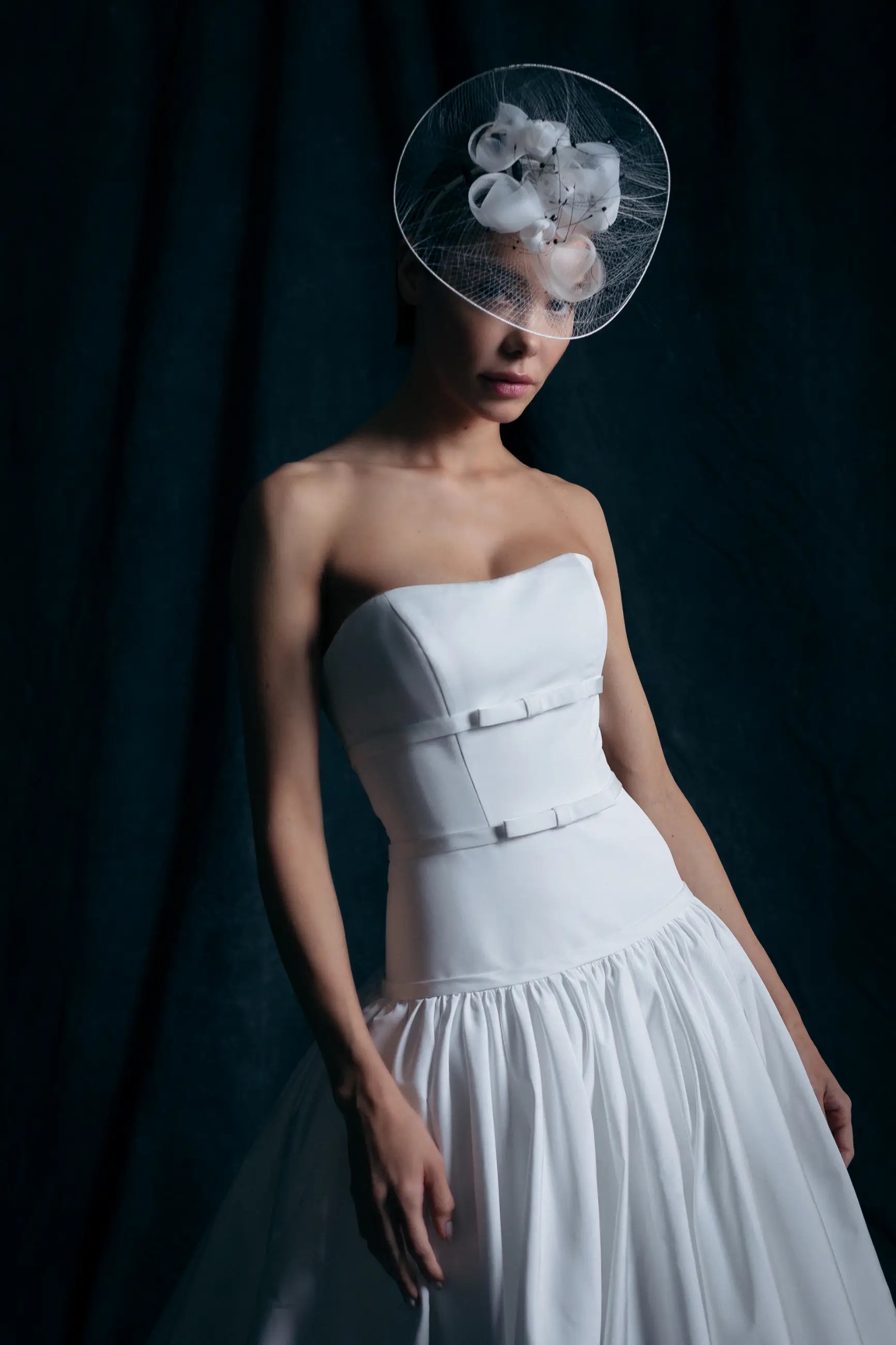 model is wearing a strapless drop waist ball gown wedding dress