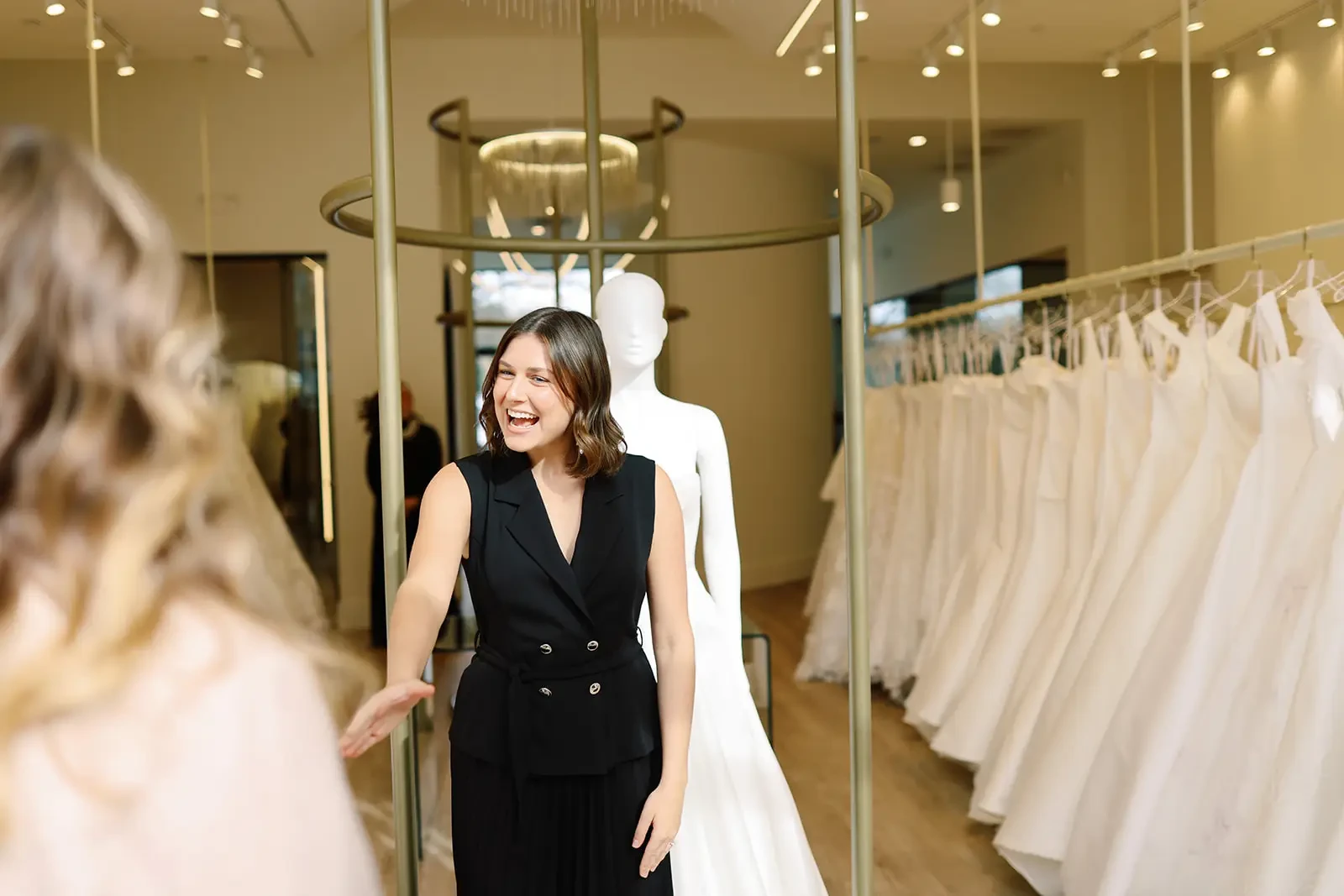 image shows bridal stylist smiling and greeting a bride to help her find her wedding dress at ladies of lineage