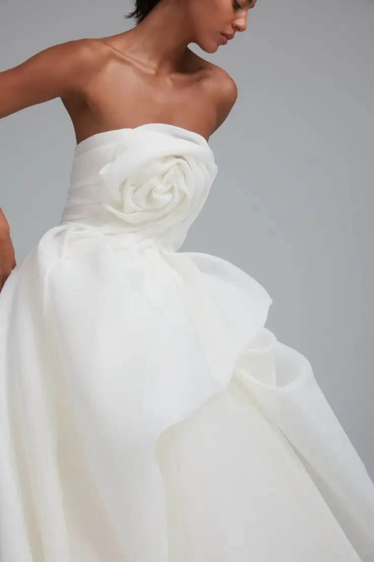 Model is wearing a hand-draped gazar ball gown with a flowing tulle skirt, each gown uniquely shaped for an organic silhouette.