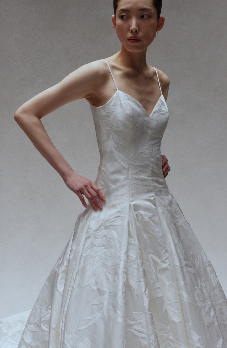model is wearing a sleeveless ball gown wedding dress