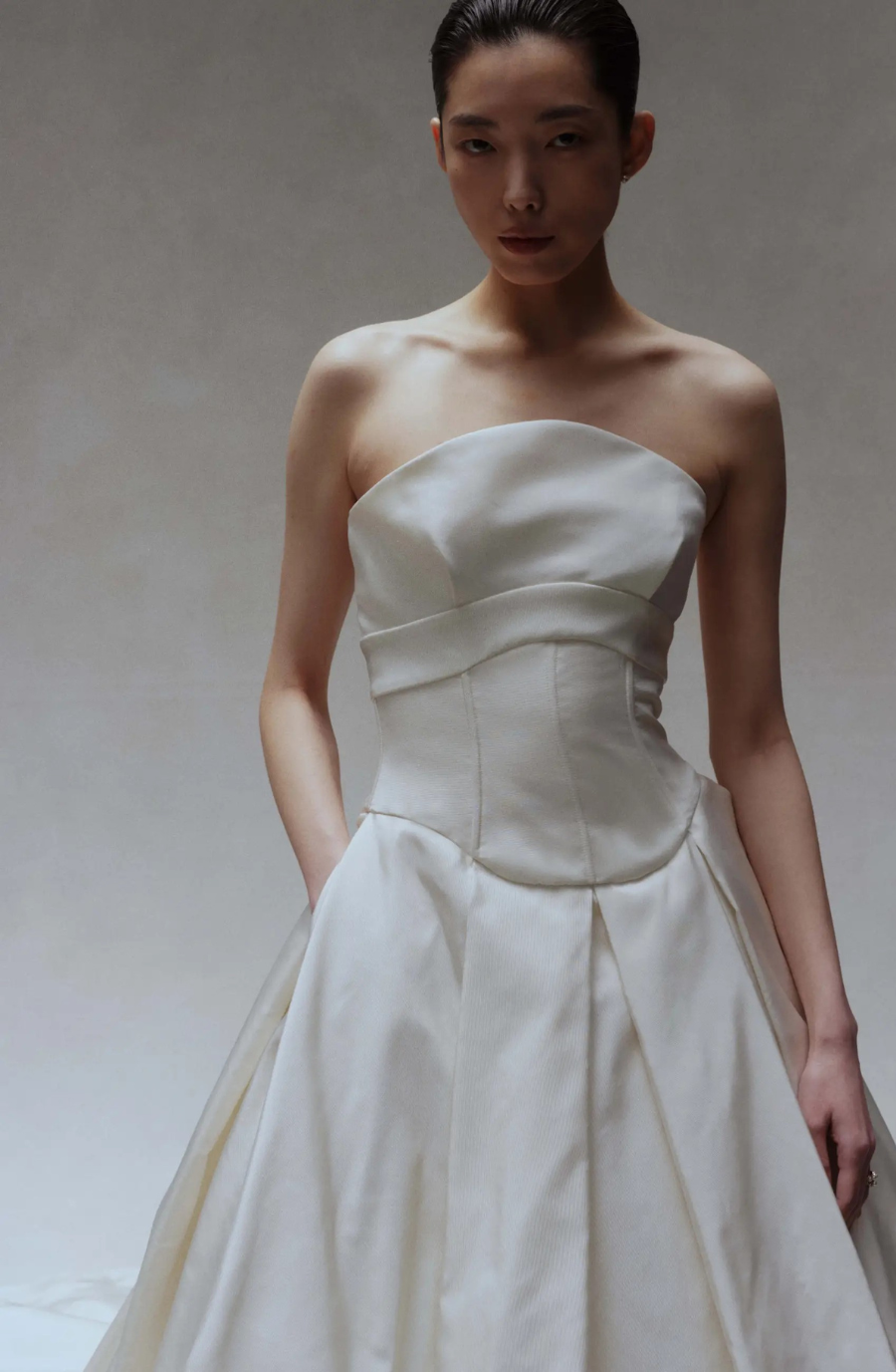 Model is wearing a strapless ball gown wedding dress with intricate texture by amsale couture
