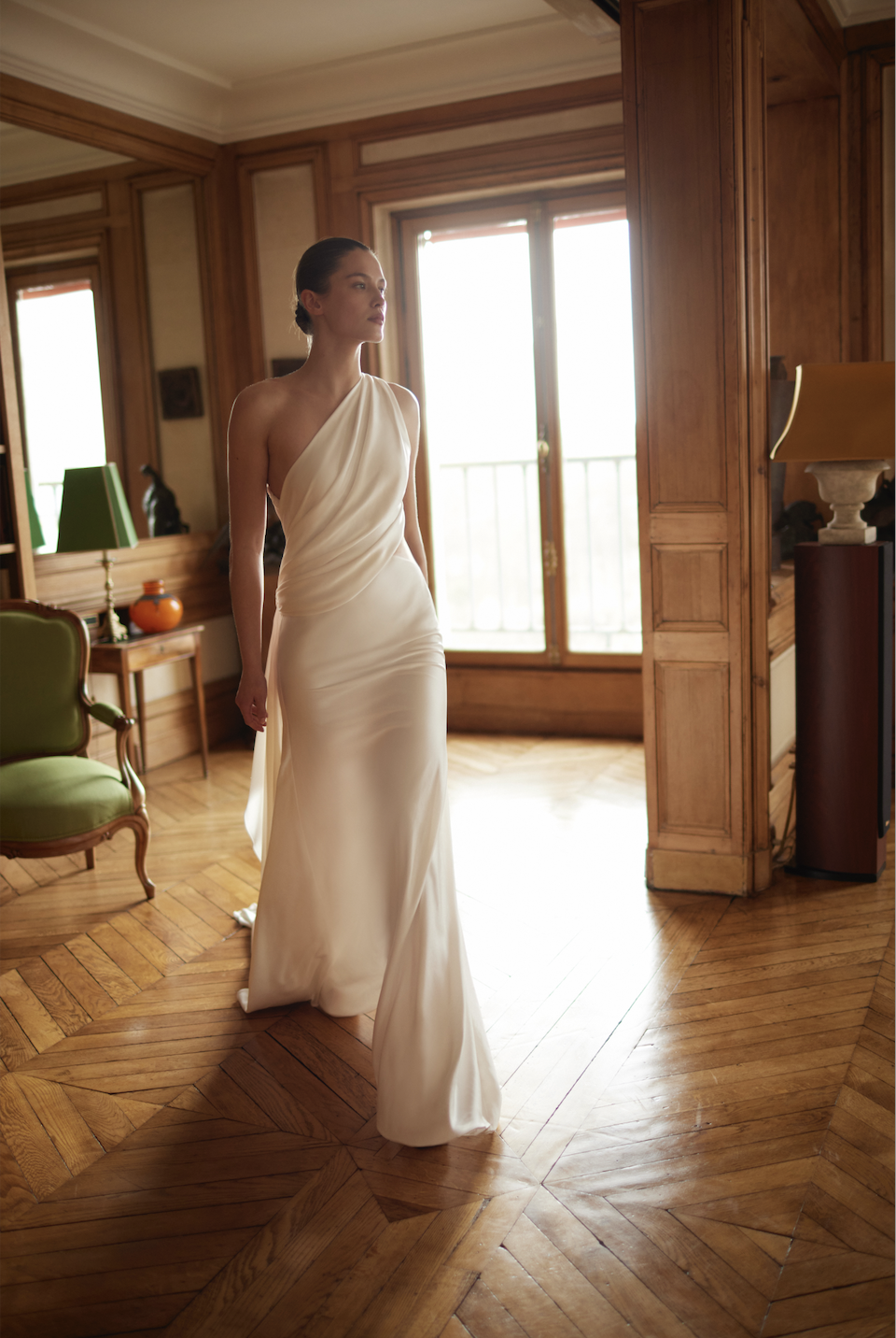 model is wearing a one shoulder asymmetrical neckline wedding dress by dana harel
