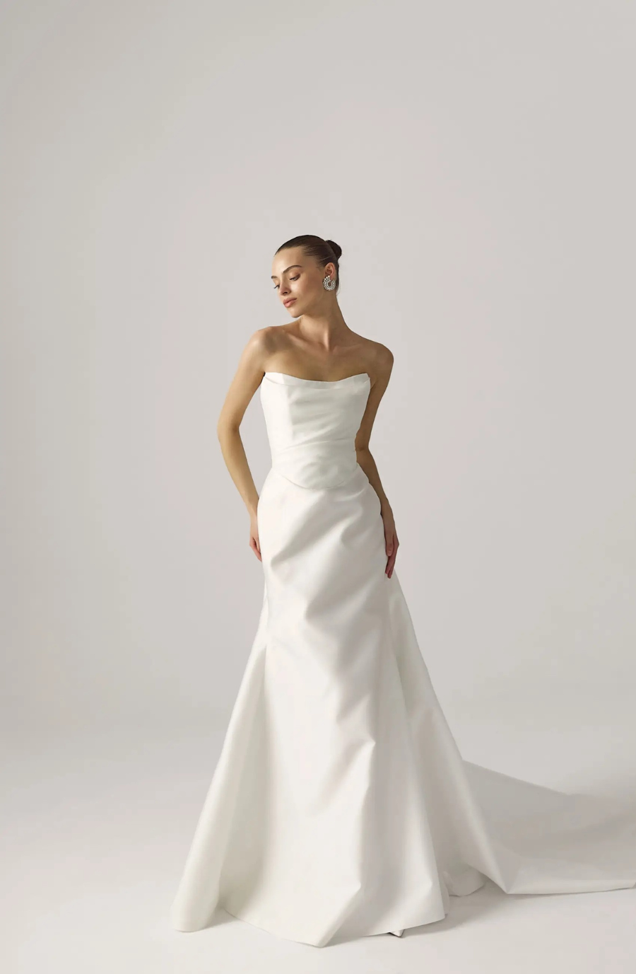 Model is wearing a strapless scoop neck fit and flare wedding dress by lihi hod