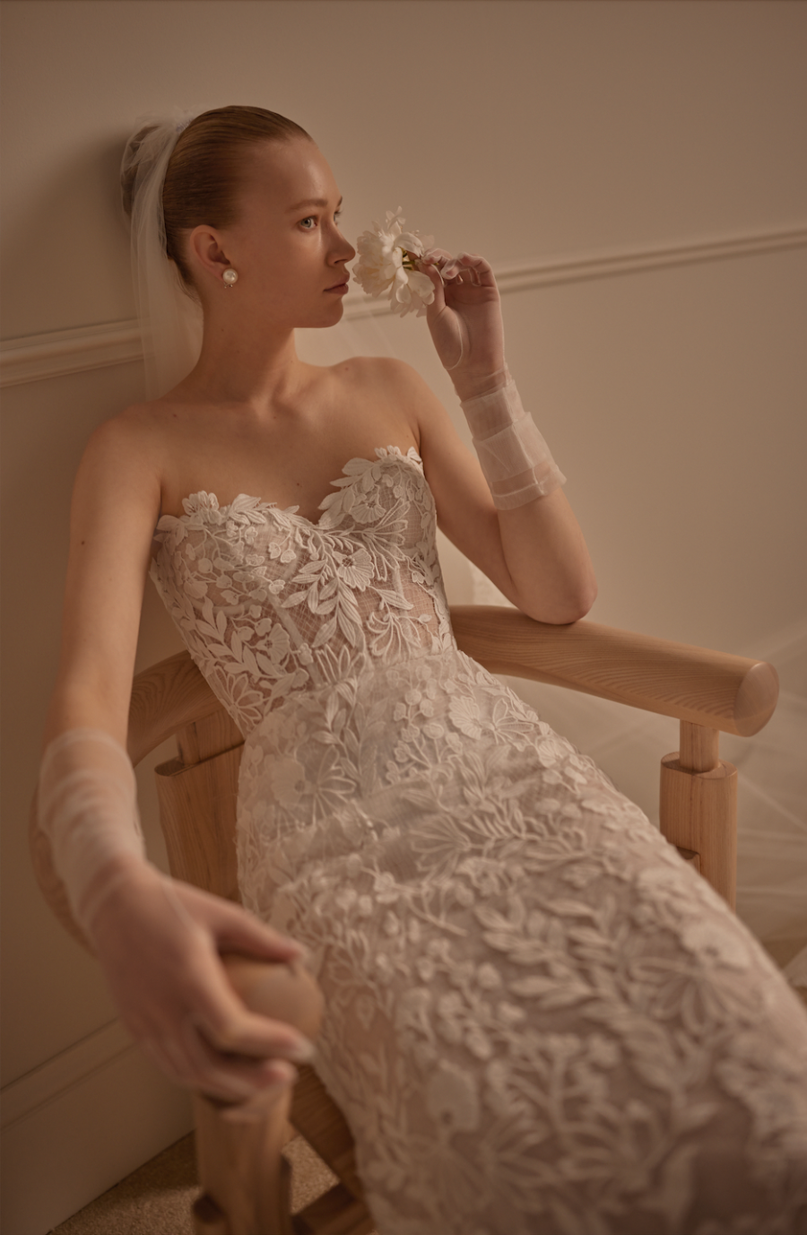 Model is wearing a lace fit and flare bridal gown with a sculpted silhouette and semi sheer bodice by lihi hod