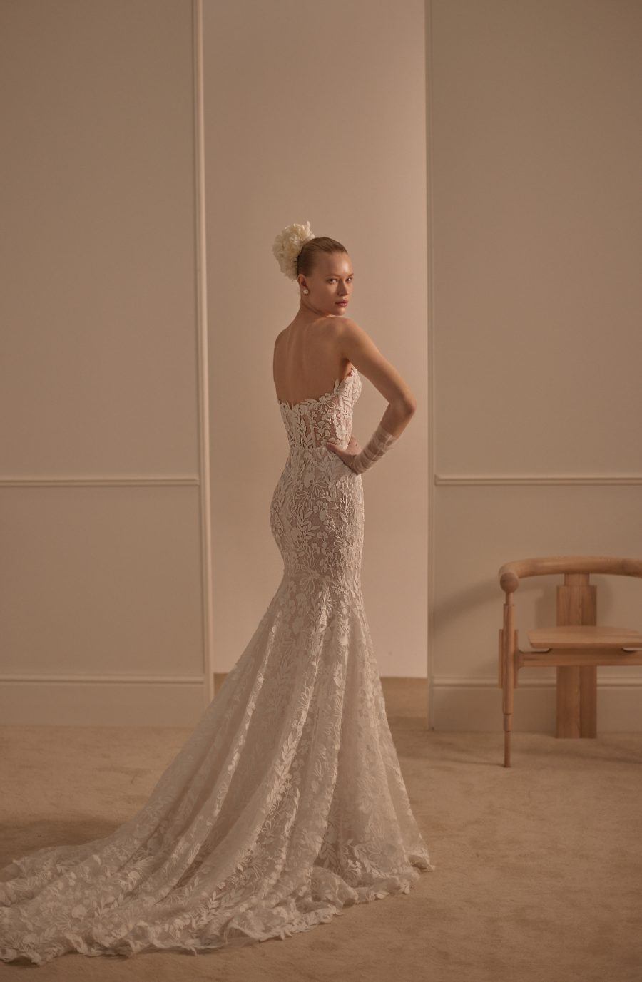 Model is wearing a lace fit and flare bridal gown with a sculpted silhouette and semi sheer bodice by lihi hod