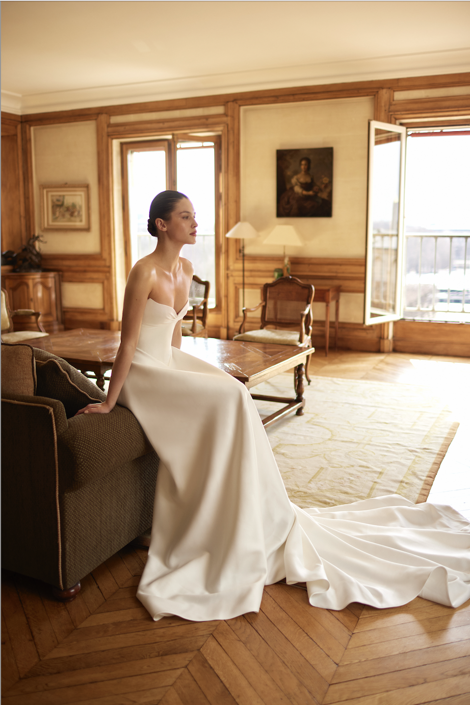 model is wearing a strapless fit and flare bridal gown by dana harel