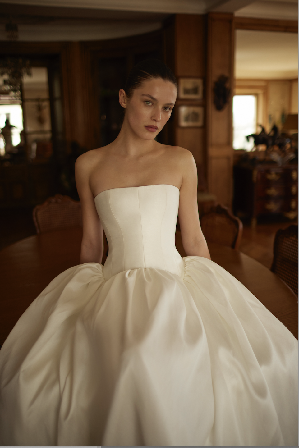 model is wearing a strapless ball gown wedding dress by dana harel