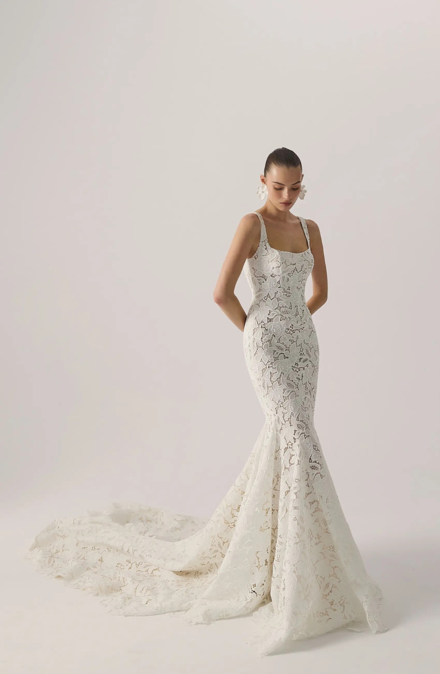 Model is wearing a sleeveless fit and flare lace bridal gown with a square neckline by lihi hod